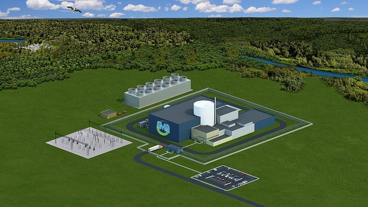 Appalachian Power Targets Joshua Falls SMR in Campbell County Virginia A 3D rendering of a Small Modular Reactor (SMR) power plant complex, set in a green, forested landscape next to a river.